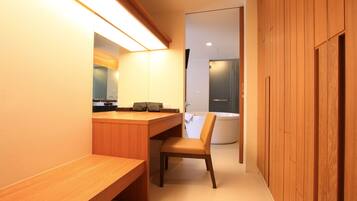 A modern bathroom with a wooden vanity, a chair, and a bathtub.
