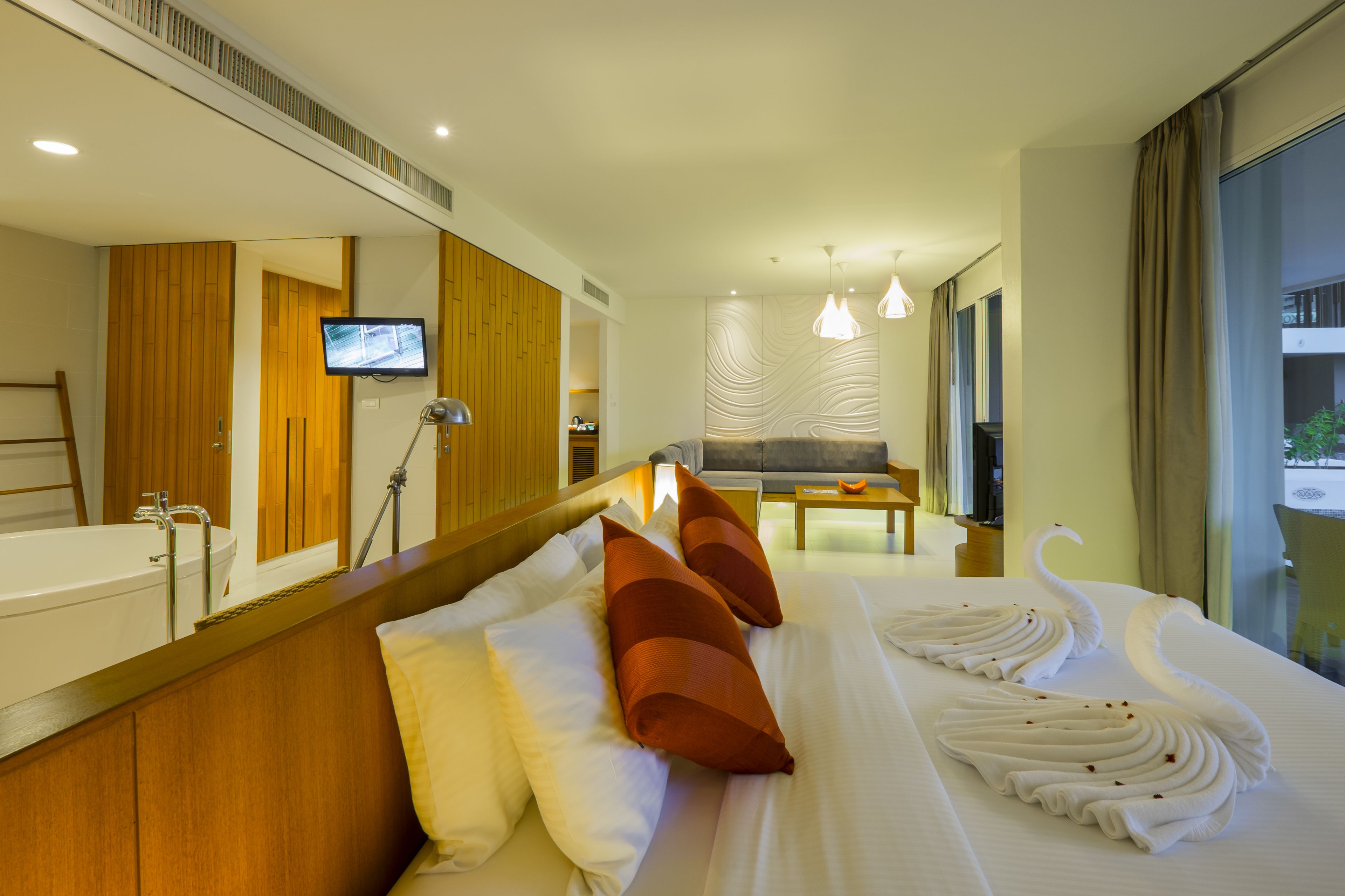 Habitación de hotel con una cama grande, televisión, baño y vistas al exterior.