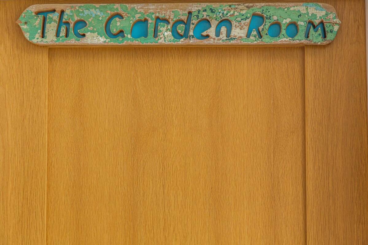 Una puerta de madera con un letrero que dice "The Garden Room".