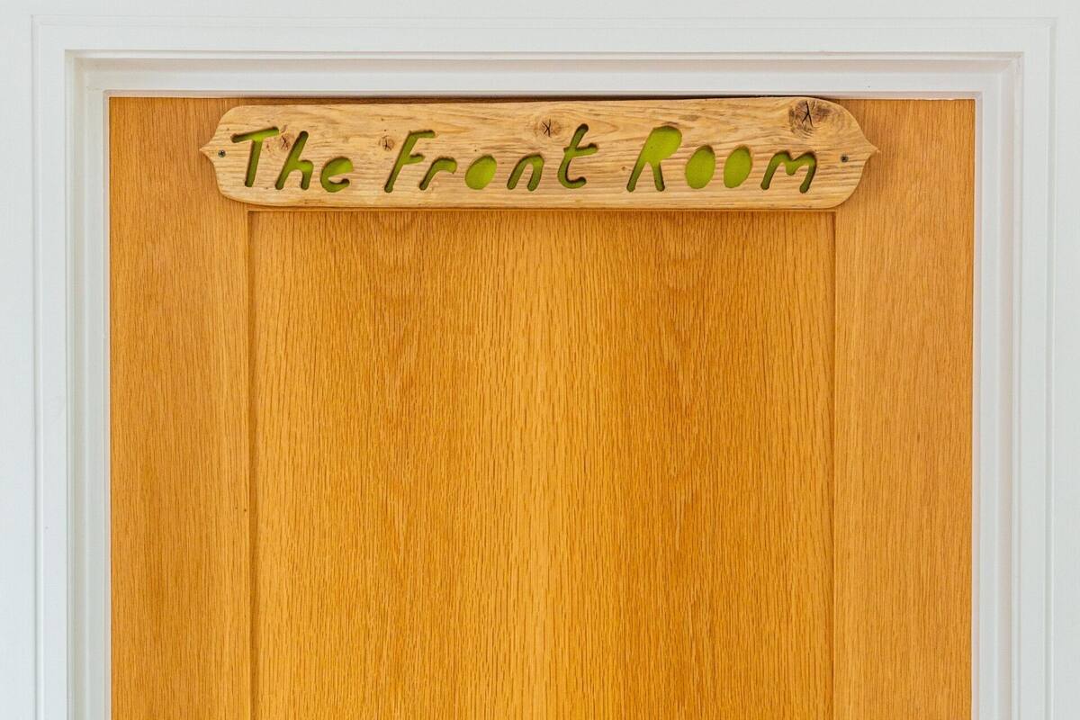 Una puerta de madera con un cartel encima que dice 'The Front Room'.