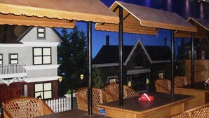 Een restaurant met terras, houten tafels en stoelen.