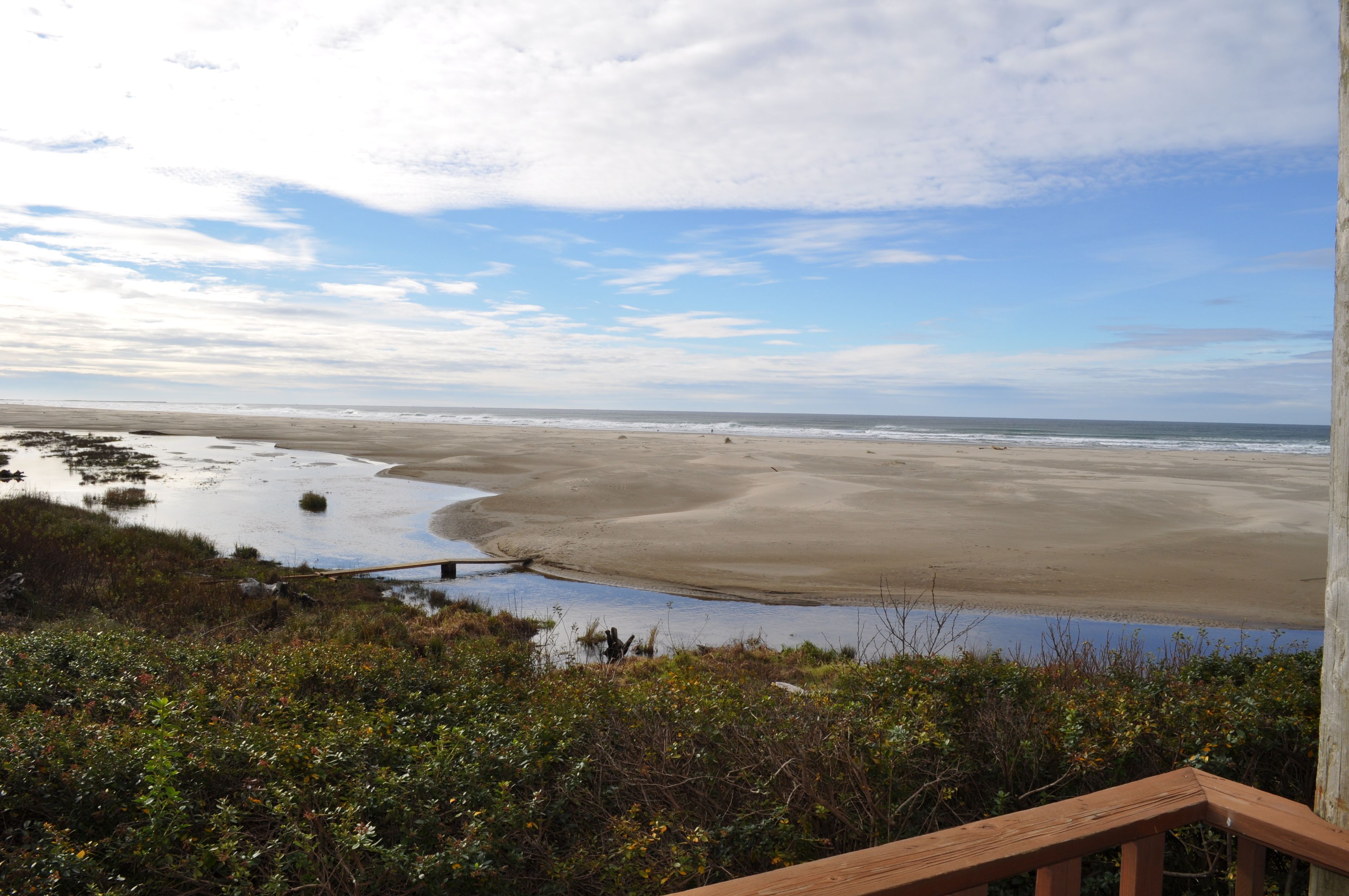 Une plage avec une terrasse en bois et une vue sur l’océan.