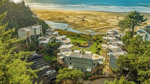 A coastal residential area with houses, a beach, and a parking lot.