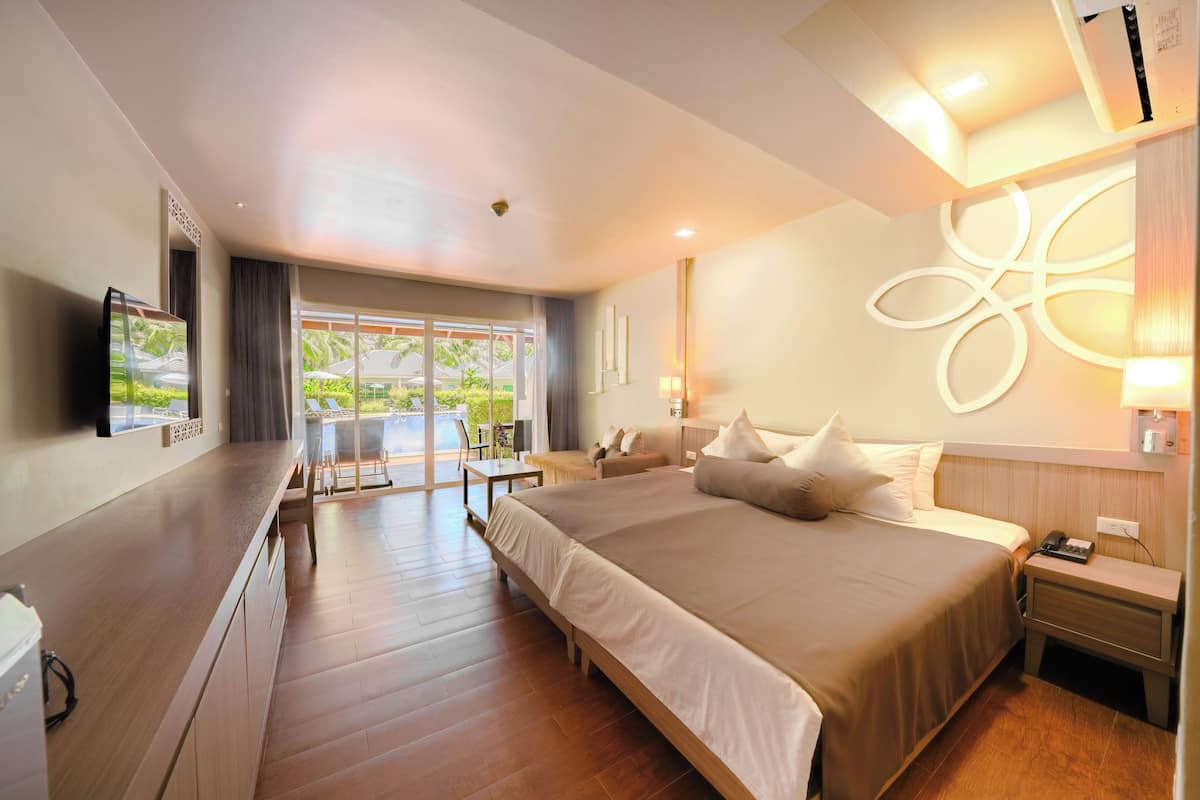 Ein modernes Hotelzimmer mit einem großen Bett, einem Schreibtisch und Blick ins Freie.