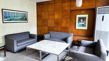 A modern living room with a sofa set, a coffee table, and a framed picture on the wall.