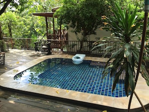 A small, rectangular swimming pool with a tiled interior, surrounded by a wooden deck and a metal fence. - Reuan Thai Village Samui (Koh Samui)