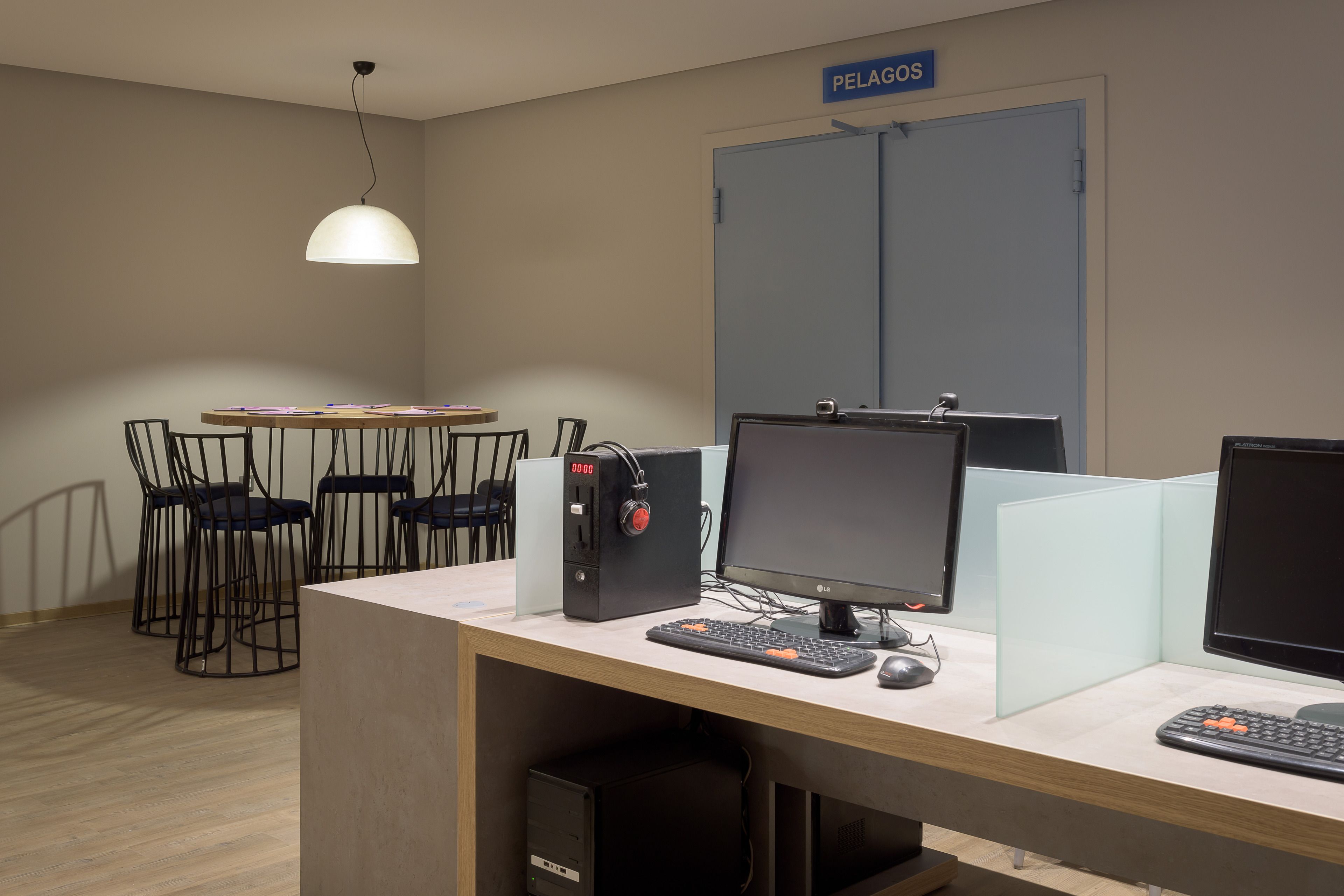 Et arbejdsområde med skriveborde, computere og stole.