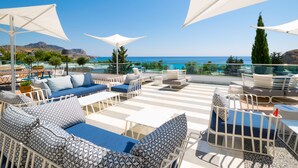 A rooftop terrace with outdoor seating, a pool, and a view of the sea. - Porto Angeli Beach Resort – All Inclusive (Rhodes)