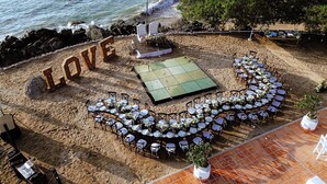 A beach wedding setup with a stage, tables, and chairs arranged for guests. - Hotel Azul Ixtapa Grand Resort Spa and Convention Center - All inclusive (Ixtapa)