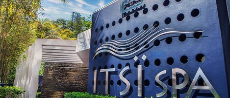 Entrada de un spa con un cartel grande que dice "ITSISPA" y un diseño decorativo de olas.