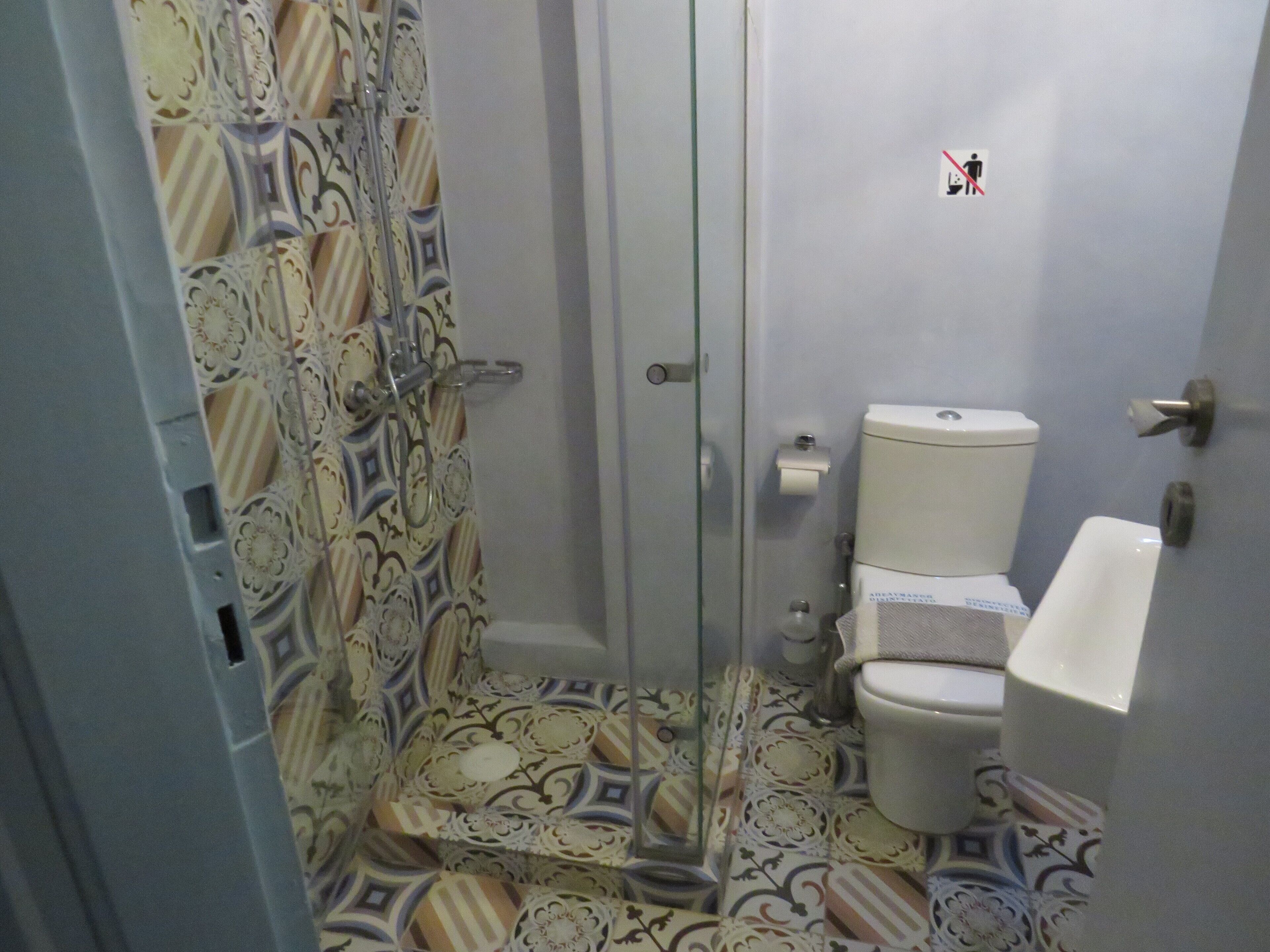 A bathroom with a patterned shower curtain, a toilet, and a sink.