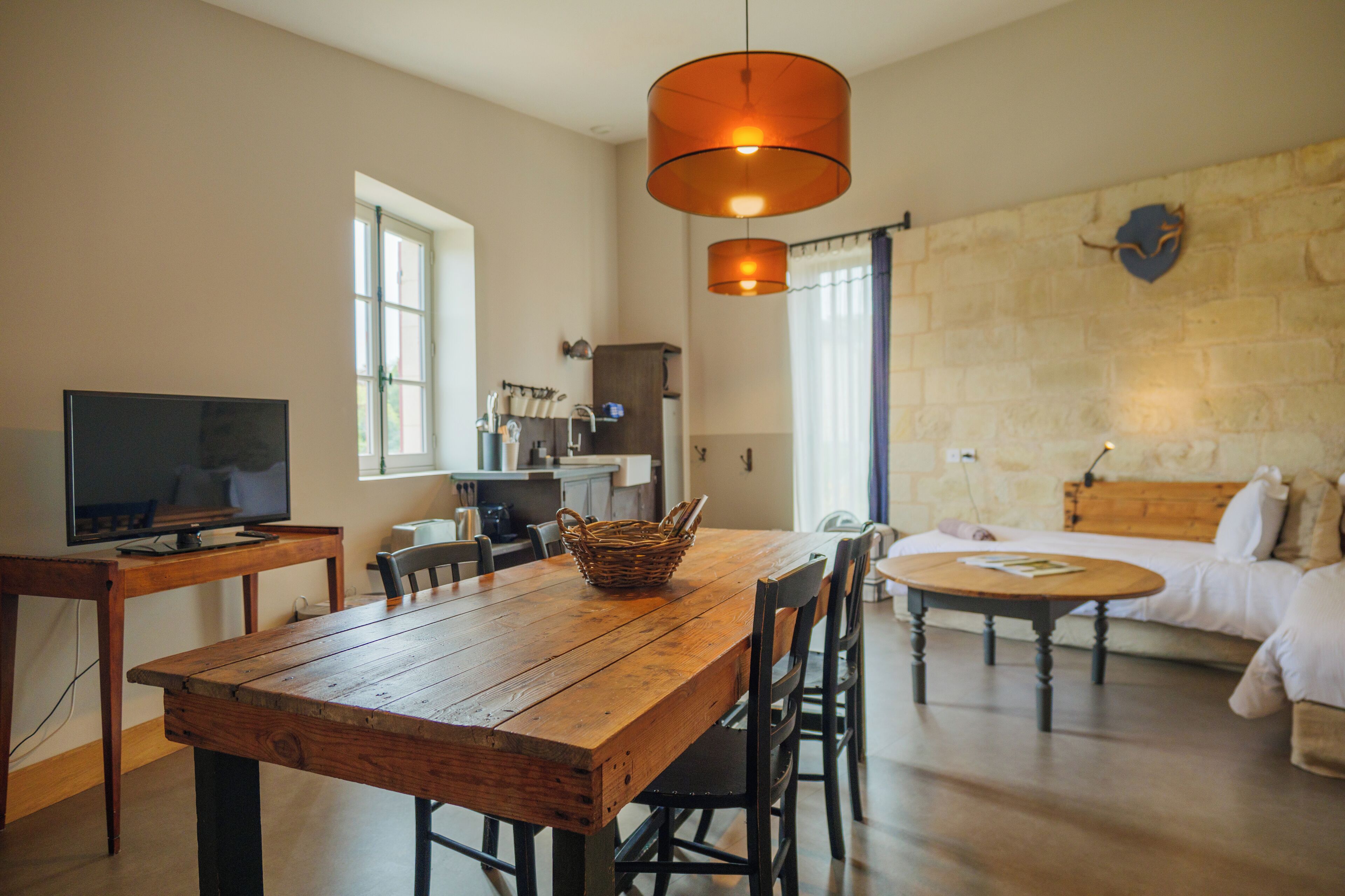 A cozy living room with a wooden dining table, a TV, and a fireplace.