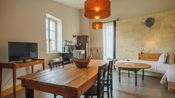 A cozy living room with a wooden dining table, a TV, and a fireplace.