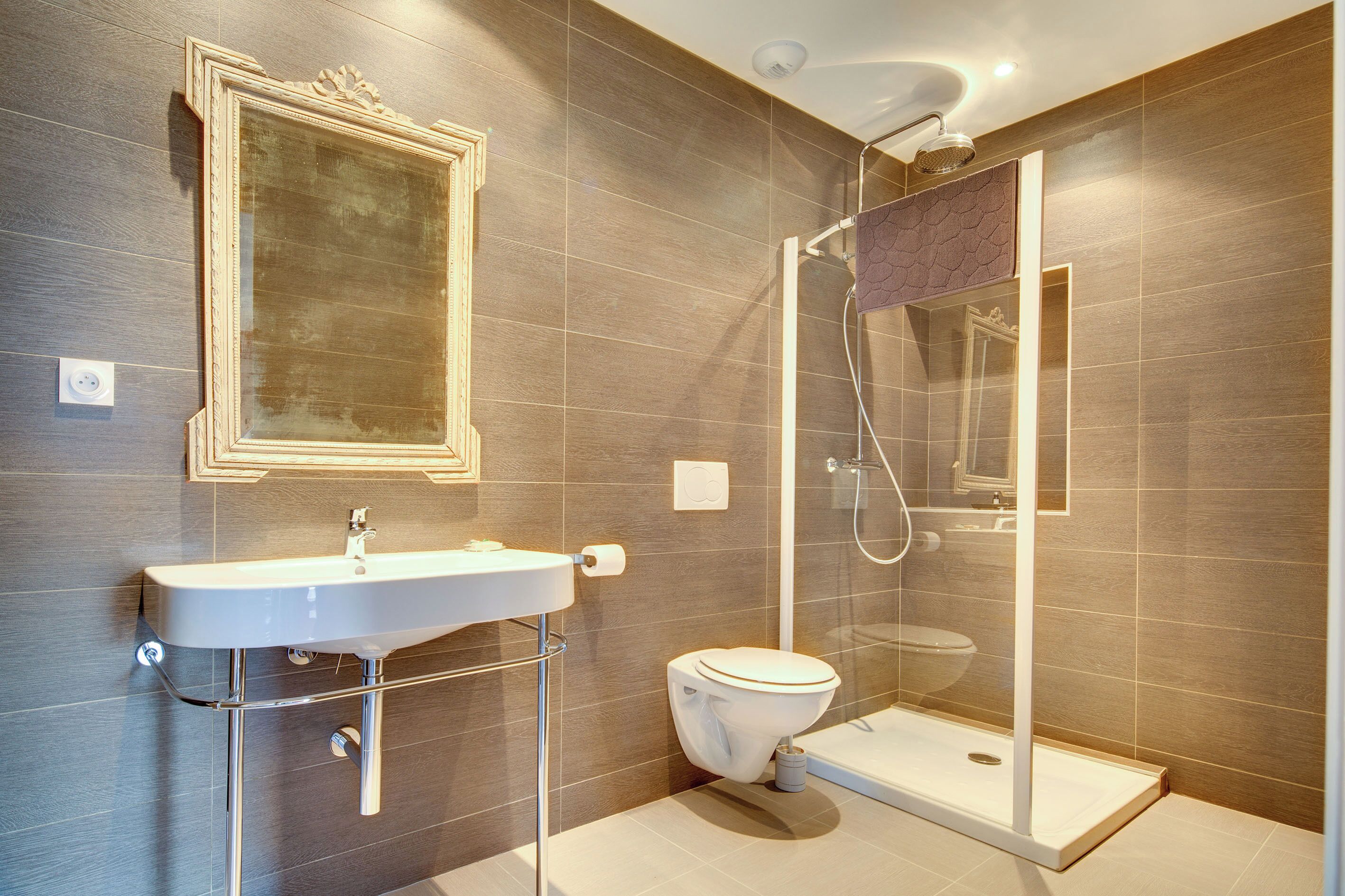A modern bathroom with a sink, toilet, and glass-enclosed shower.