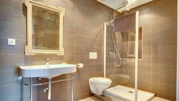 A modern bathroom with a sink, toilet, and glass-enclosed shower.