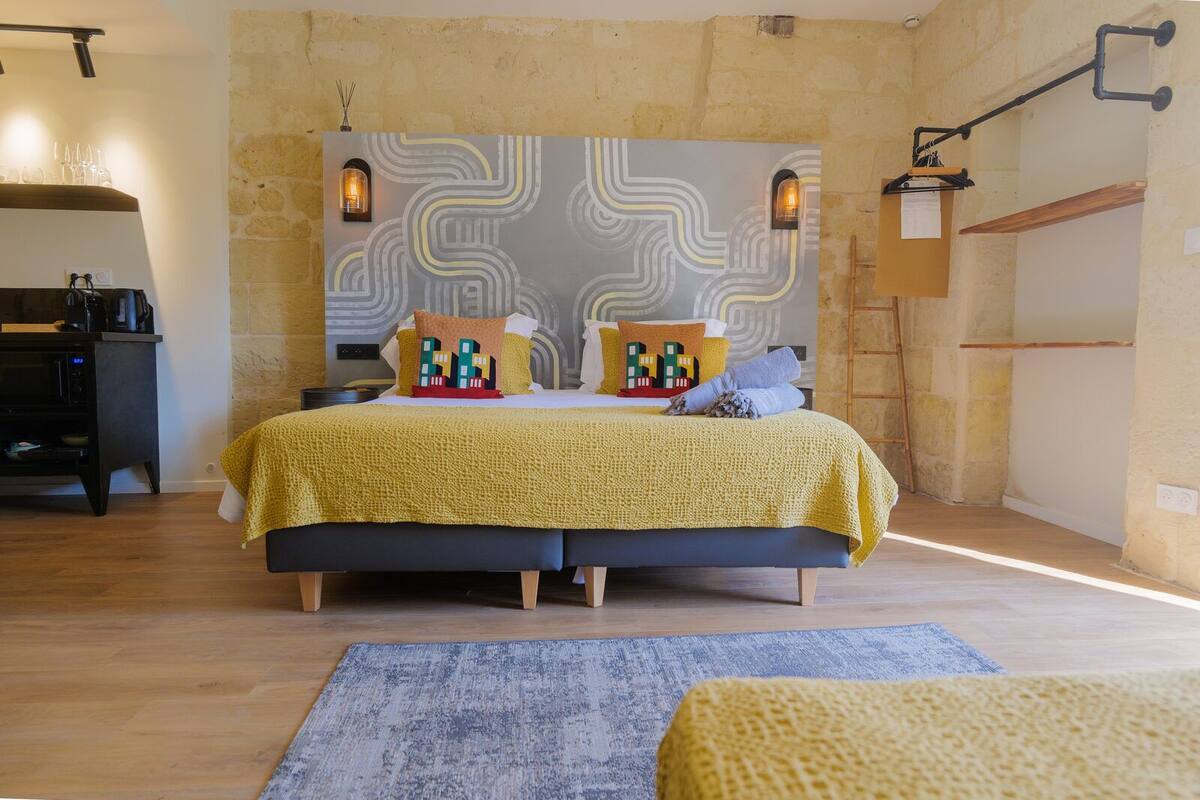 Un dormitorio con una cama, una mesita de noche, una lámpara y una pared con diseño decorativo.