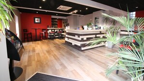 A modern interior with a reception desk, seating area, and a bar.