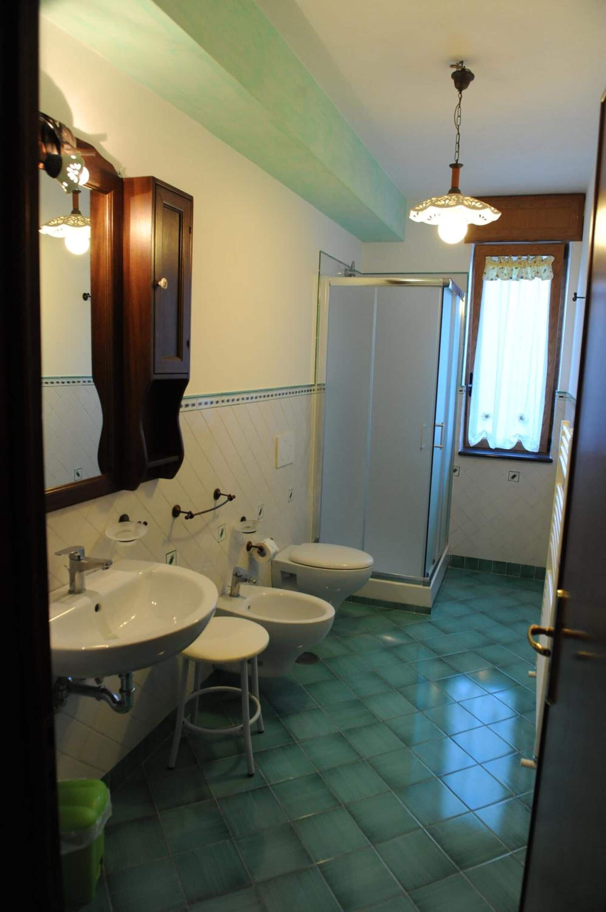 Un bagno con due lavandini, un water e una doccia.