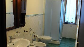 Un bagno con due lavandini, un water e una doccia.