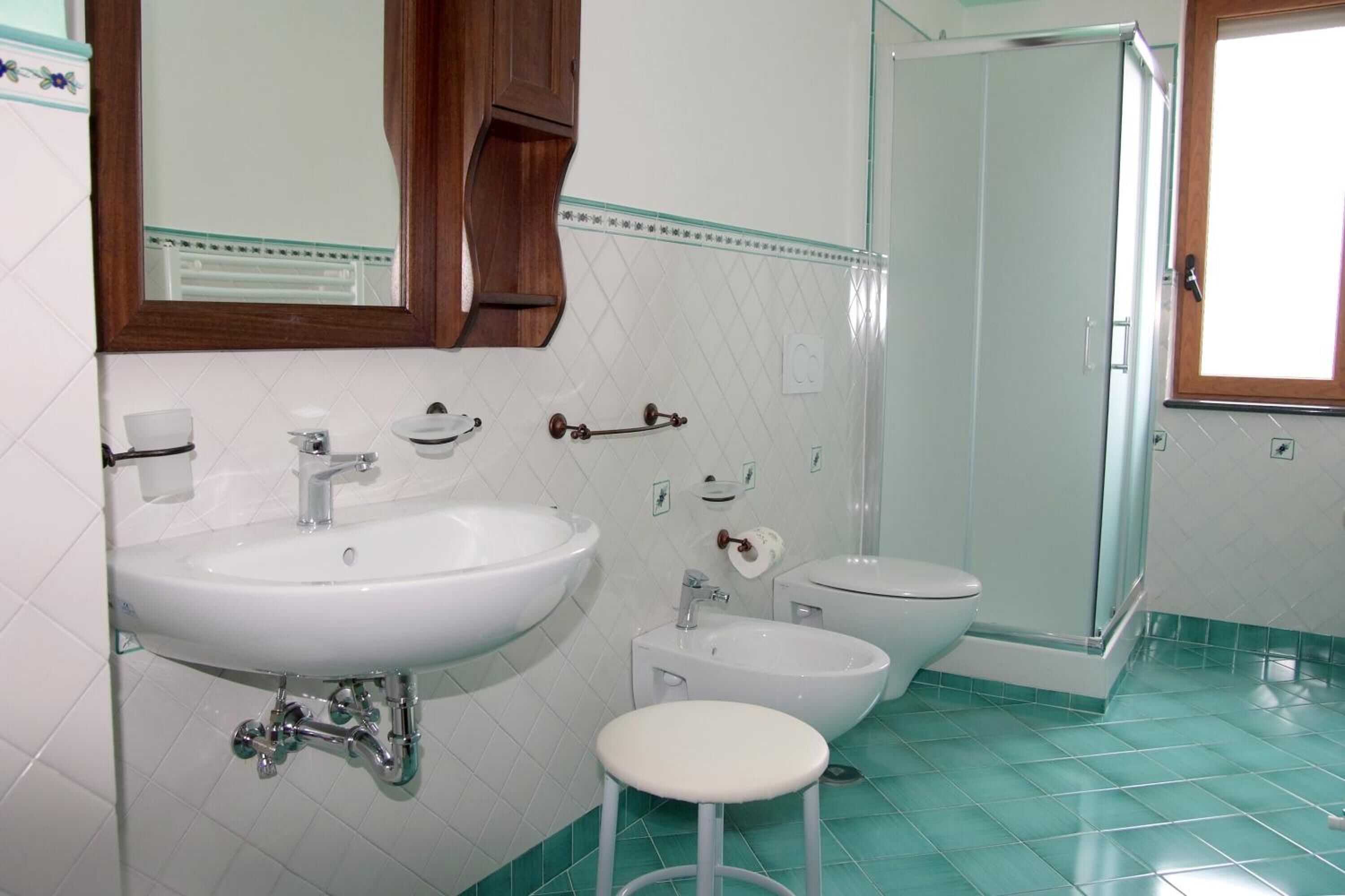 Une salle de bain avec un grand lavabo, un plus petit lavabo, des toilettes et une douche.