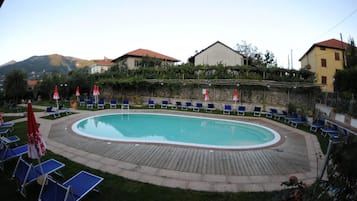 Una piscina al aire libre de temporada, sombrillas, tumbonas