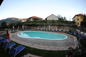 Una piscina al aire libre de temporada, sombrillas