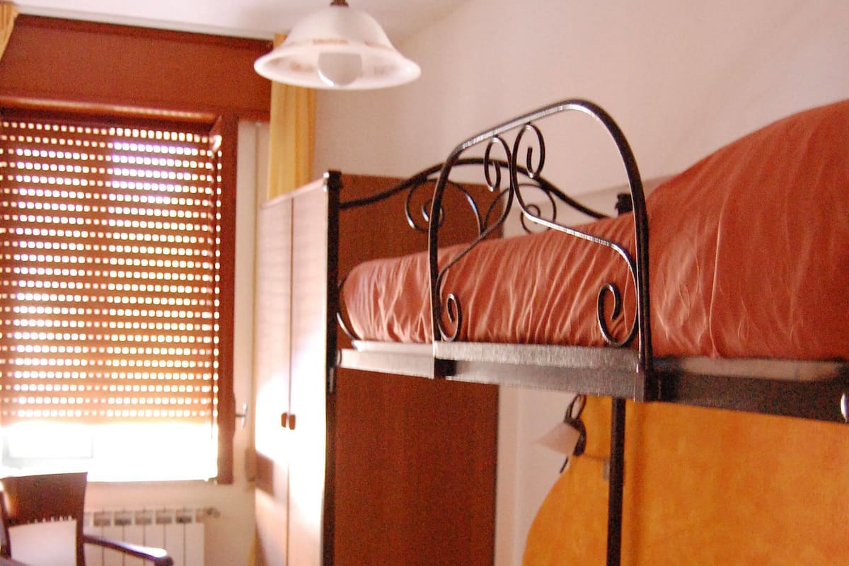 A bunk bed room with a chair and a radiator.