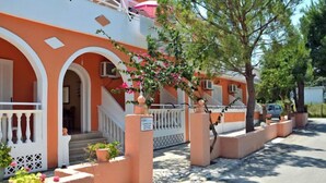 Un edificio di due piani con un balcone, una scala e piante in vaso.