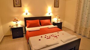 Una camera d'albergo con un letto, due comodini e due lampade a parete.