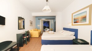 Una habitación de hotel con cama, escritorio, silla, televisor y un cuadro en la pared.
