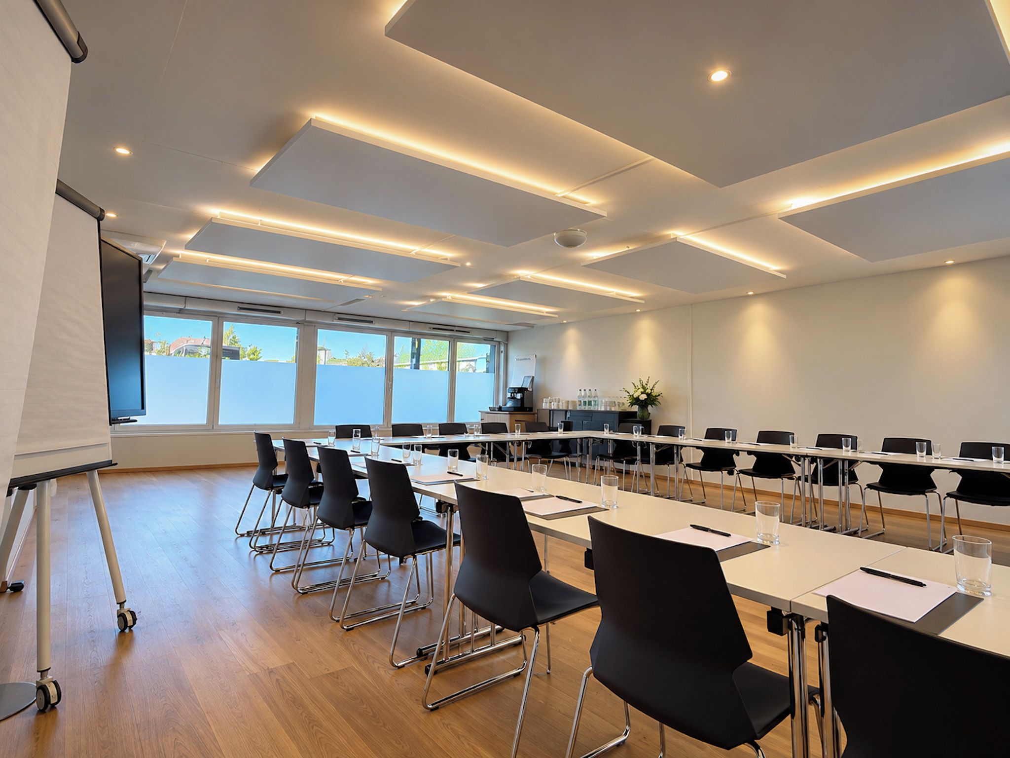 A conference room with a long table, black chairs, and a whiteboard.