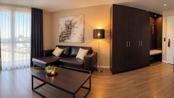 A modern living room with a sofa, coffee table, and a painting on the wall.