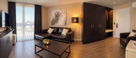 A modern living room with a sofa, coffee table, and a painting on the wall.