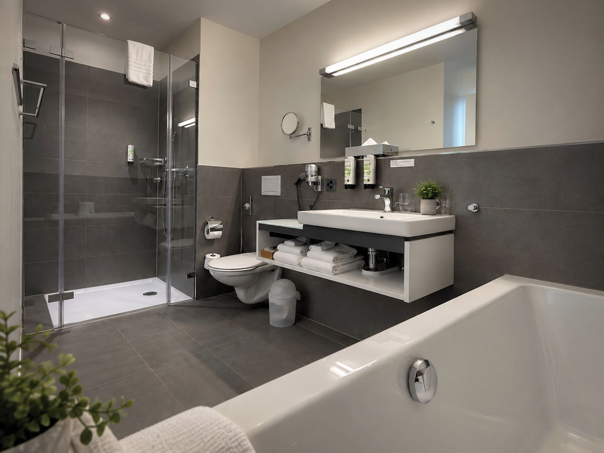 Un baño moderno con cabina de ducha de vidrio, inodoro, lavabo con espejo y bañera.