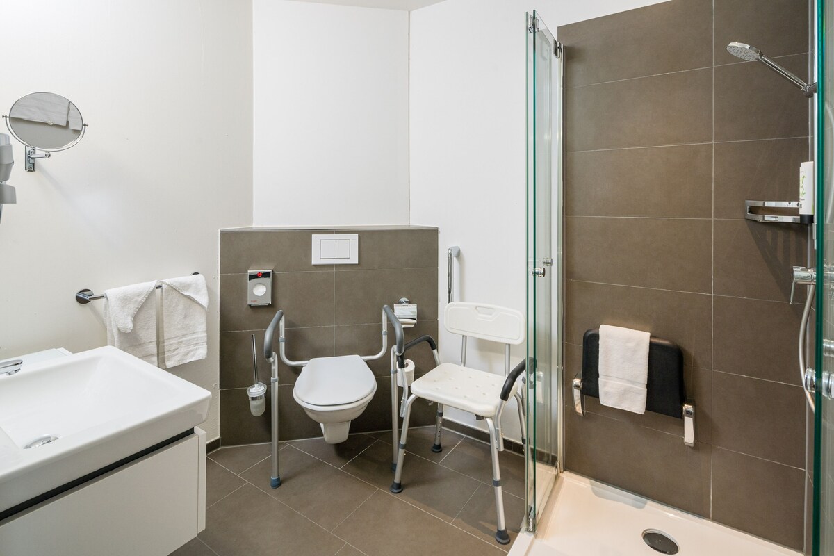 Un baño moderno con lavamanos, inodoro y ducha blancos.