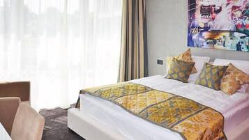 Ein Hotelzimmer mit einem großen Bett, einem Sessel und einem Bild an der Wand.