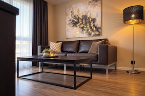 A modern living room with a leather sofa, a coffee table, and a floor lamp.