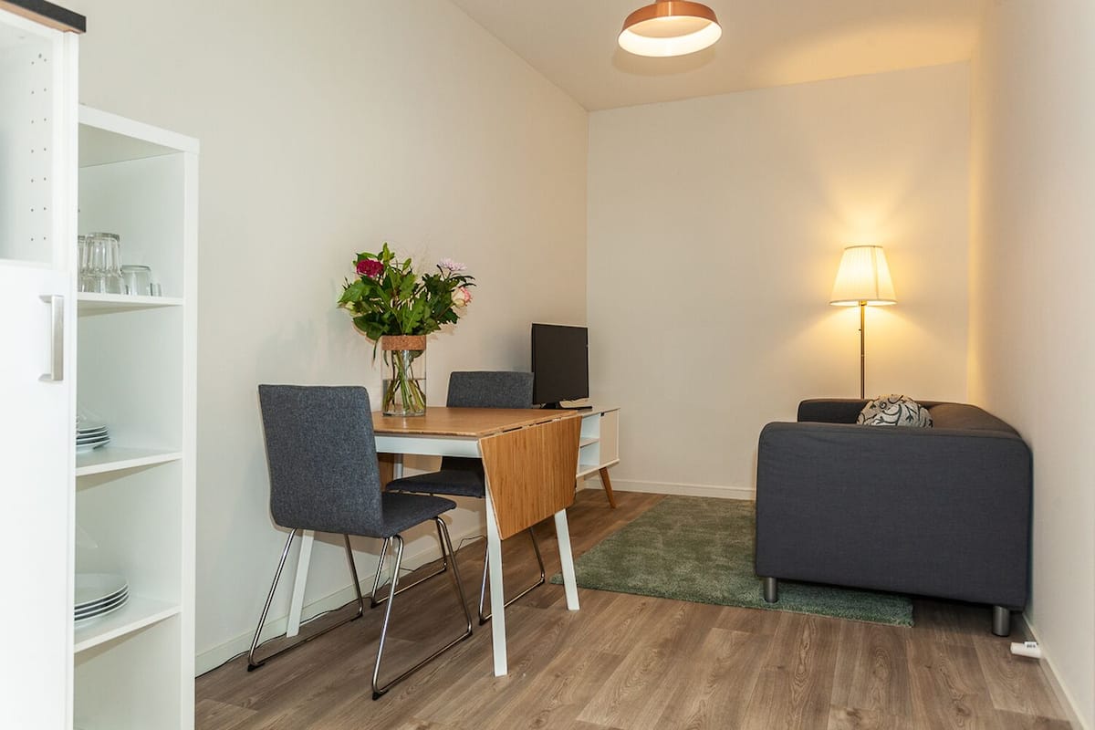 Un espacio habitable compacto con comedor, sofá y televisor.