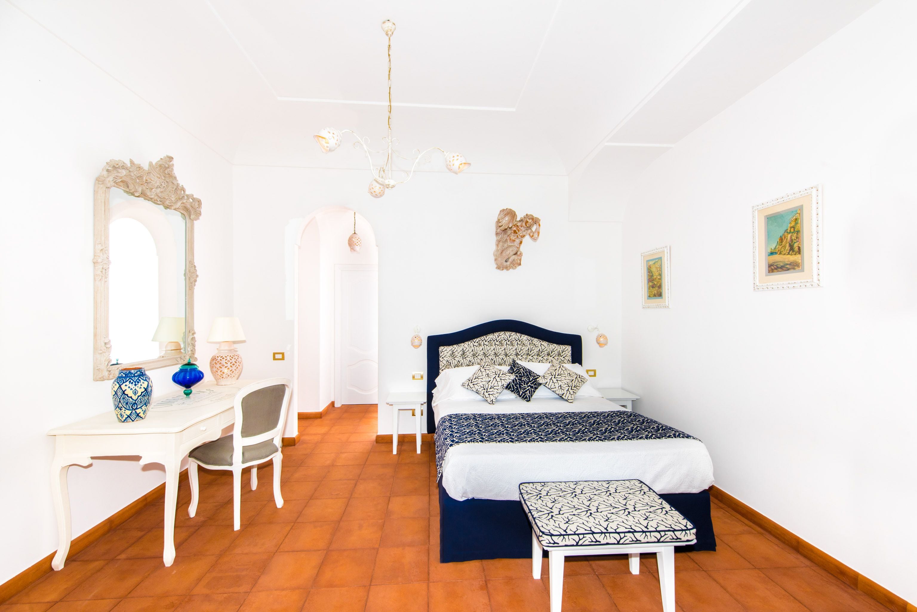 Une chambre à coucher avec un lit, un bureau, une chaise et un miroir.