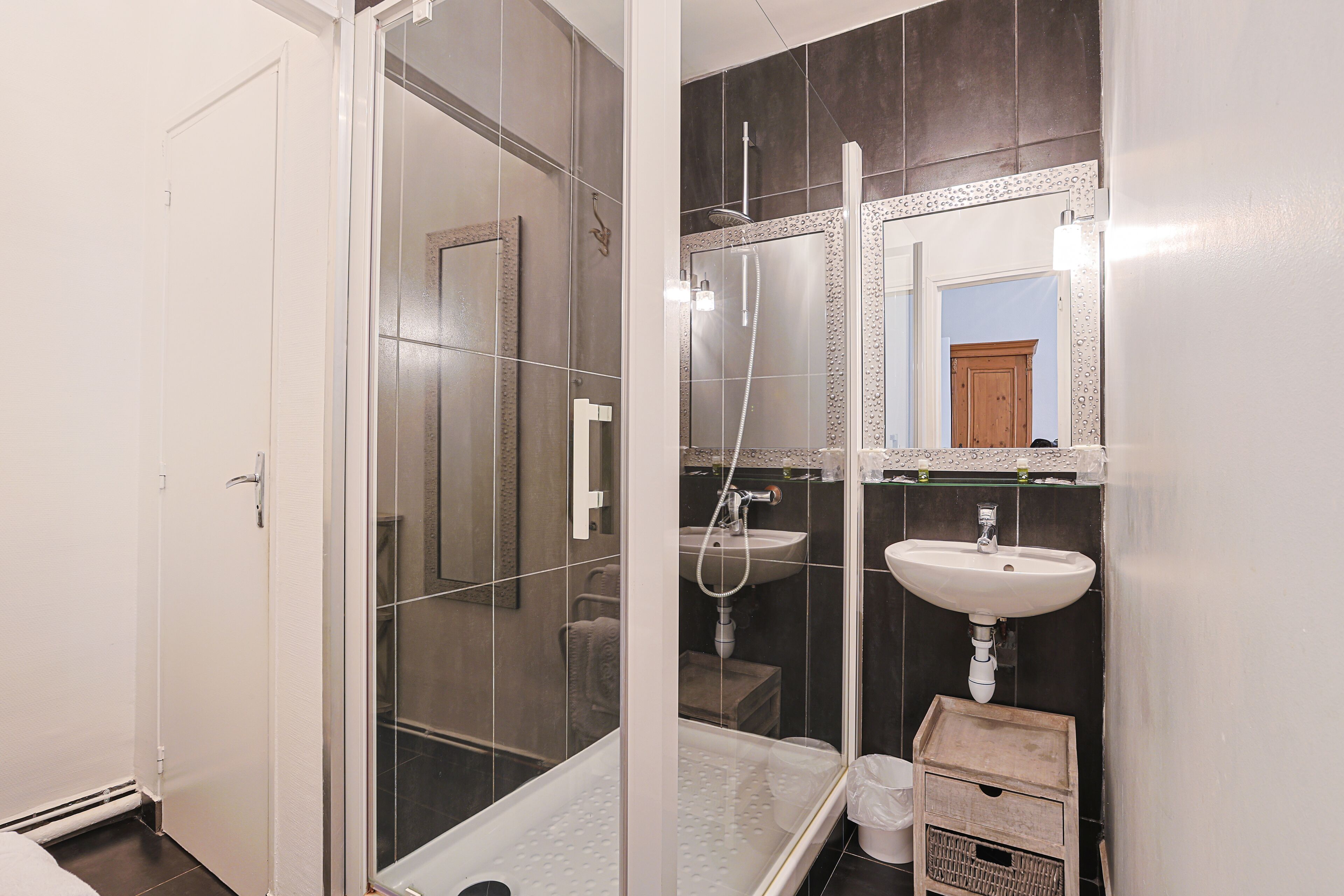 Un baño con cabina de ducha de vidrio, un lavabo y un espejo.