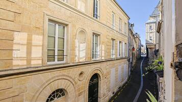 A narrow street with historic buildings, a clear sky, and a visible building entrance.