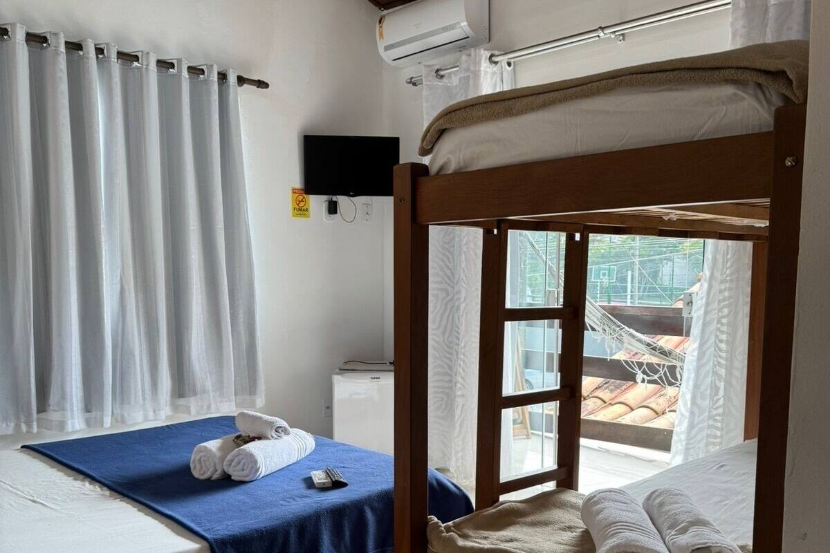 Una habitación con dos literas, un televisor y vista a un espacio exterior.