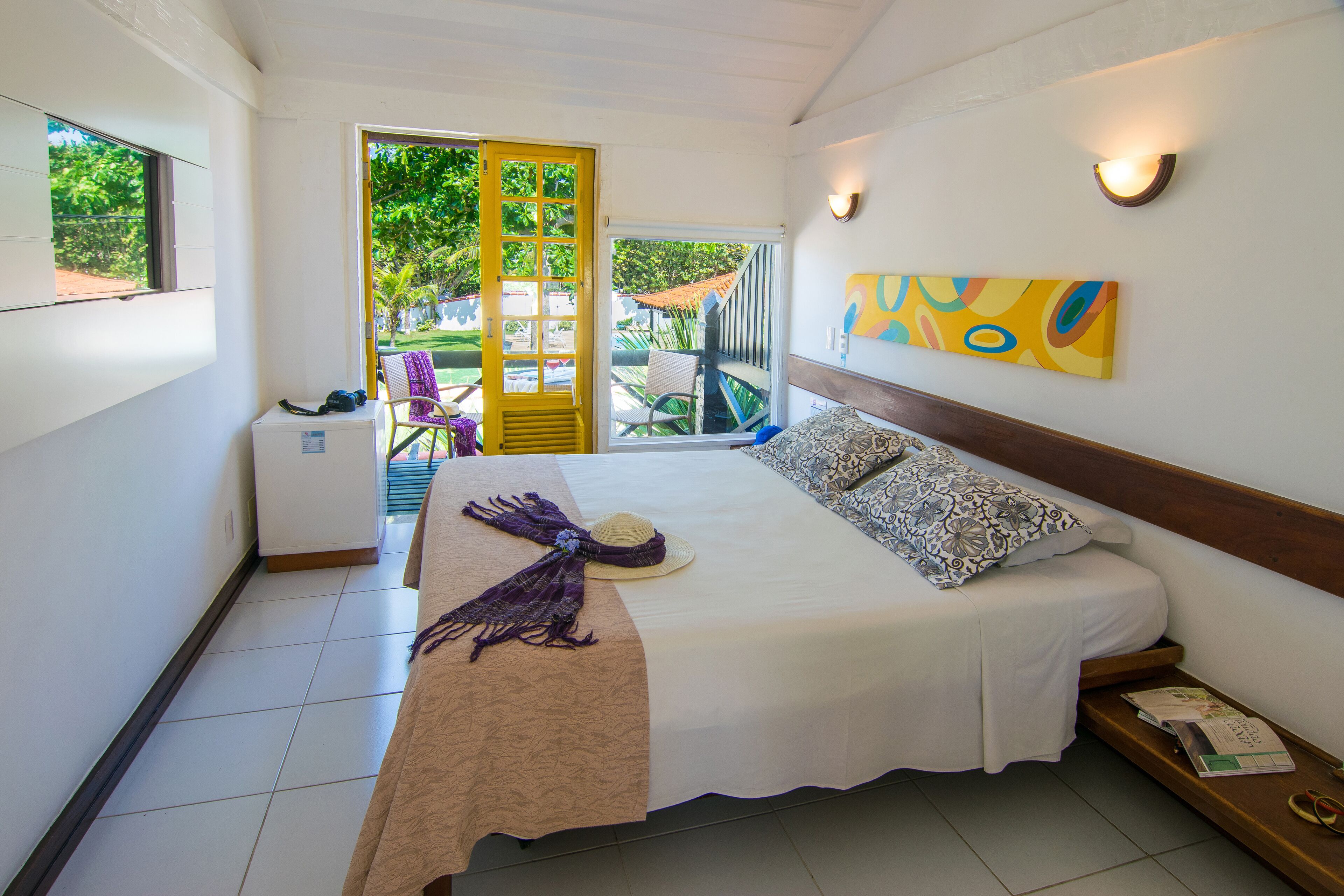 Una camera d'albergo con un letto, una piccola scrivania, una sedia e vista all'esterno.