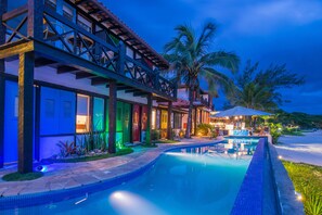 Un hotel con piscina, mobiliario exterior y palmeras.