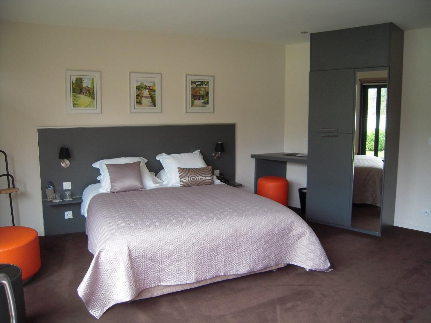 Une chambre à coucher avec un lit, des tables de chevet, un bureau et une chaise.