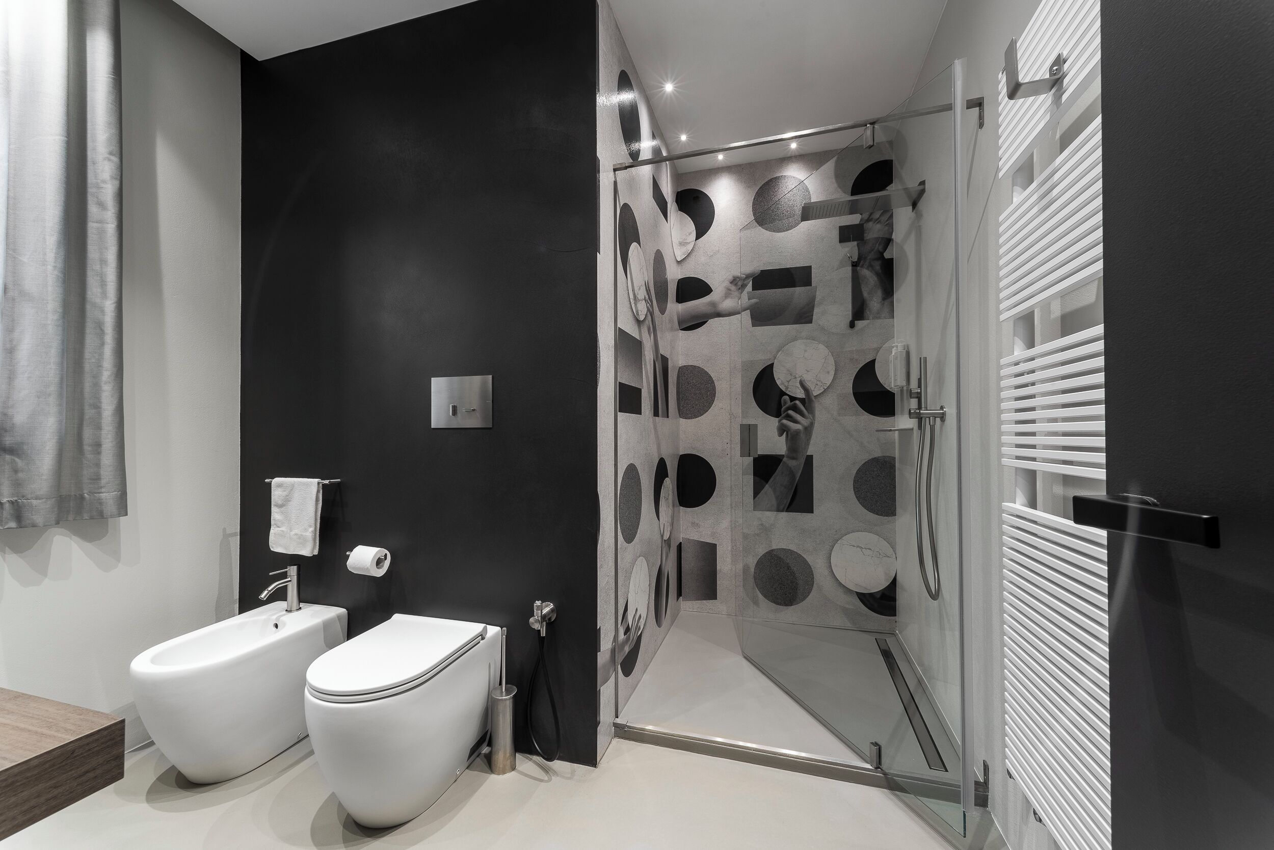 Een moderne badkamer met een toilet, douchecabine en bidet.