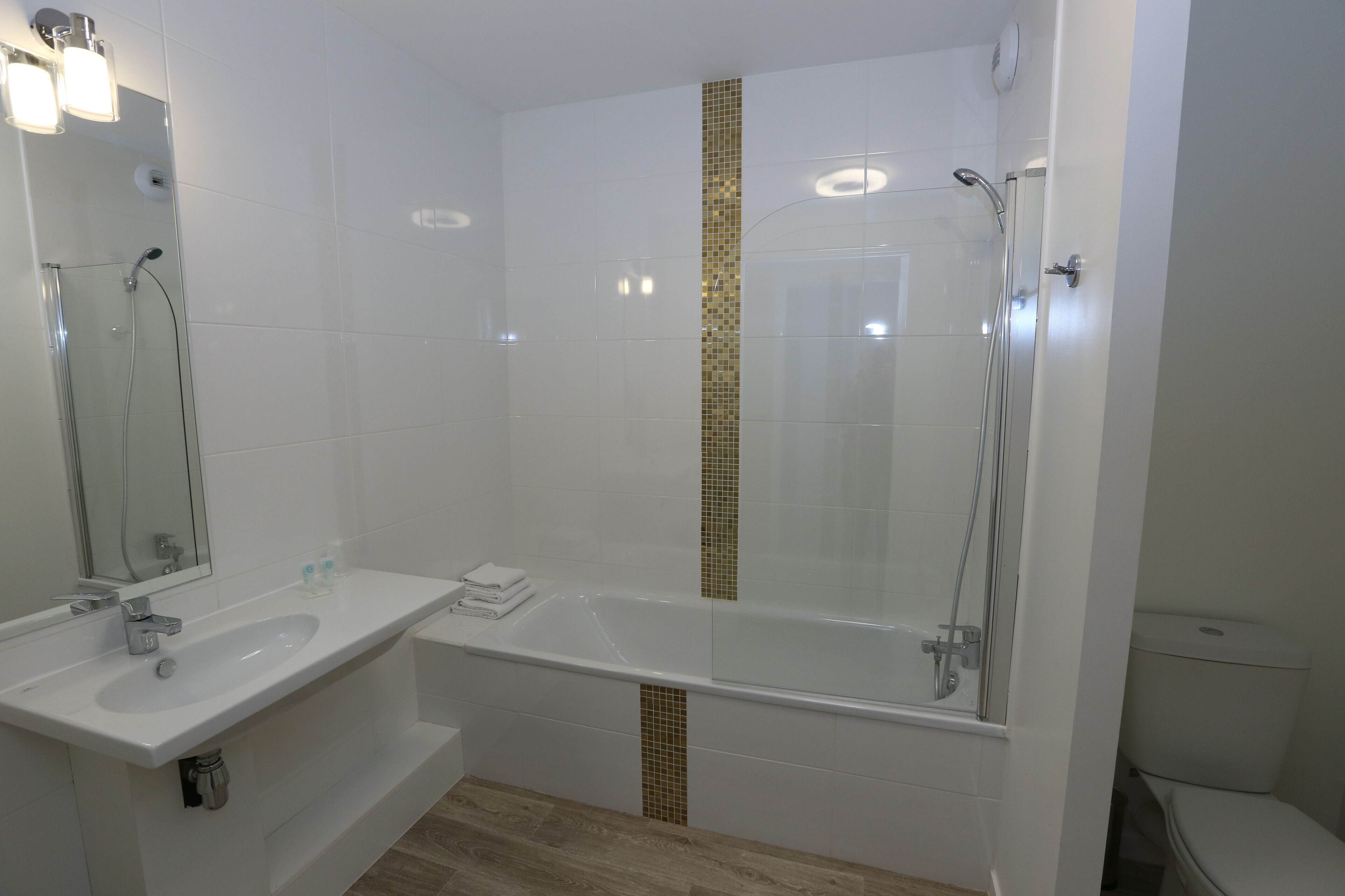 Une salle de bain moderne avec deux lavabos, une baignoire et une douche.