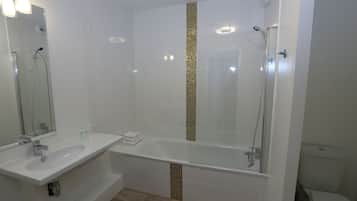A modern bathroom with two sinks, a bathtub, and a shower.