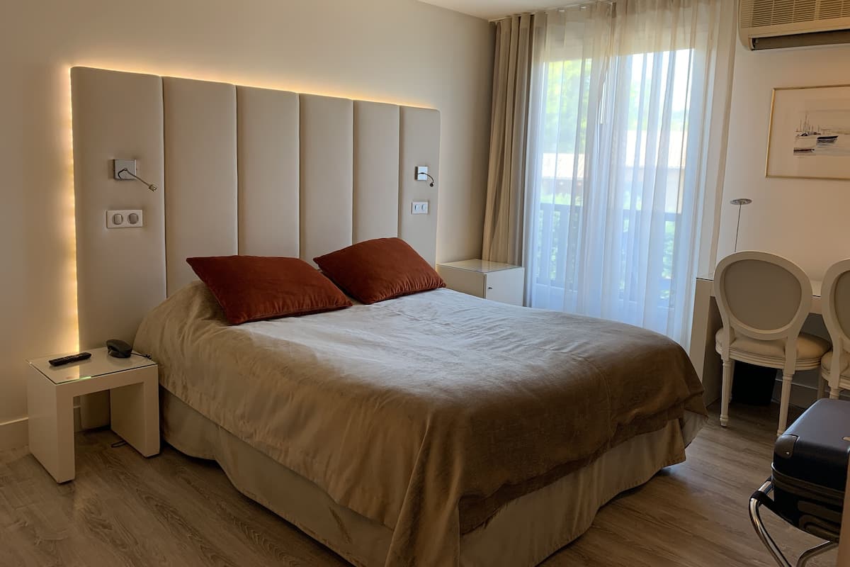 Une chambre d’hôtel moderne avec un grand lit, des tables de chevet, un bureau et une chaise.