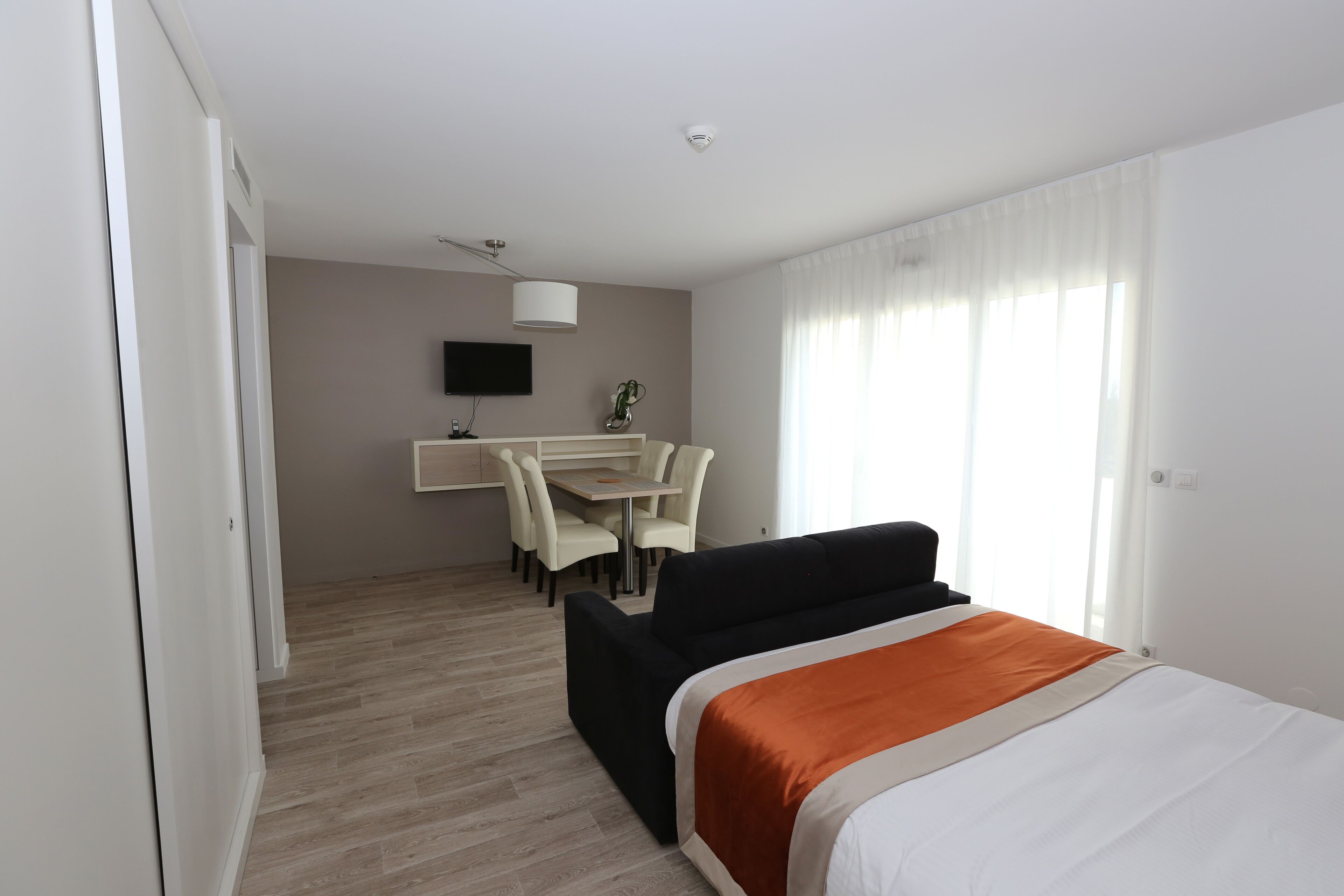 Una habitación de hotel con cama, escritorio y silla.